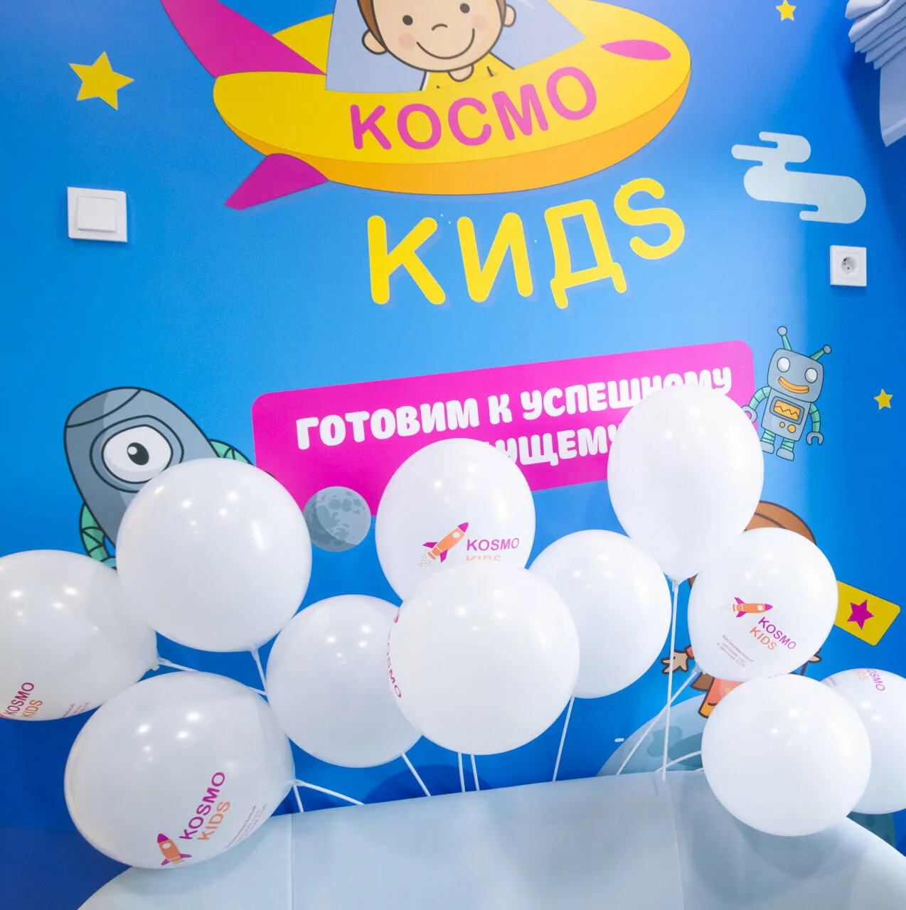 Ресепшен: стена с логотипом Космо Кидс